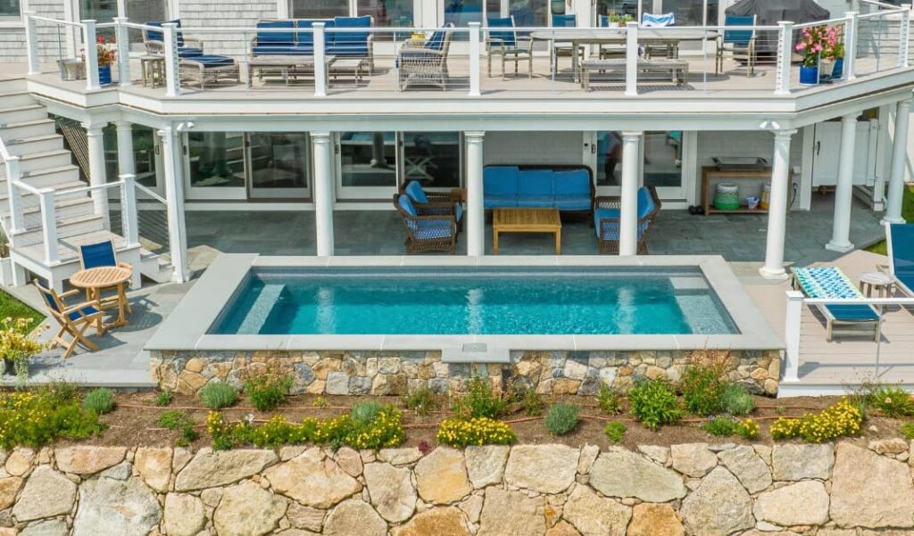 plunge pool surrounded by stone in backyard with deck and seating, concept of 2025: 10 Must-Have Features for Modern Plunge Pools
